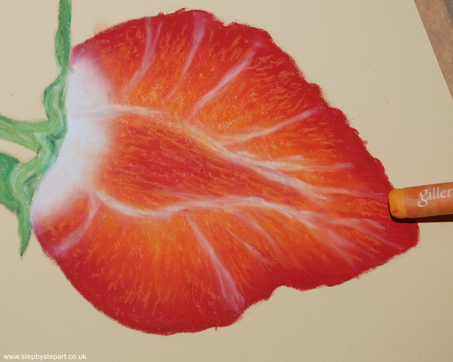 Applying a tangerine oil pastel on a drawing of a Strawberry