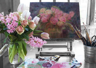 Painting on an easel of pink flowers and a vase of pink and cream tulips