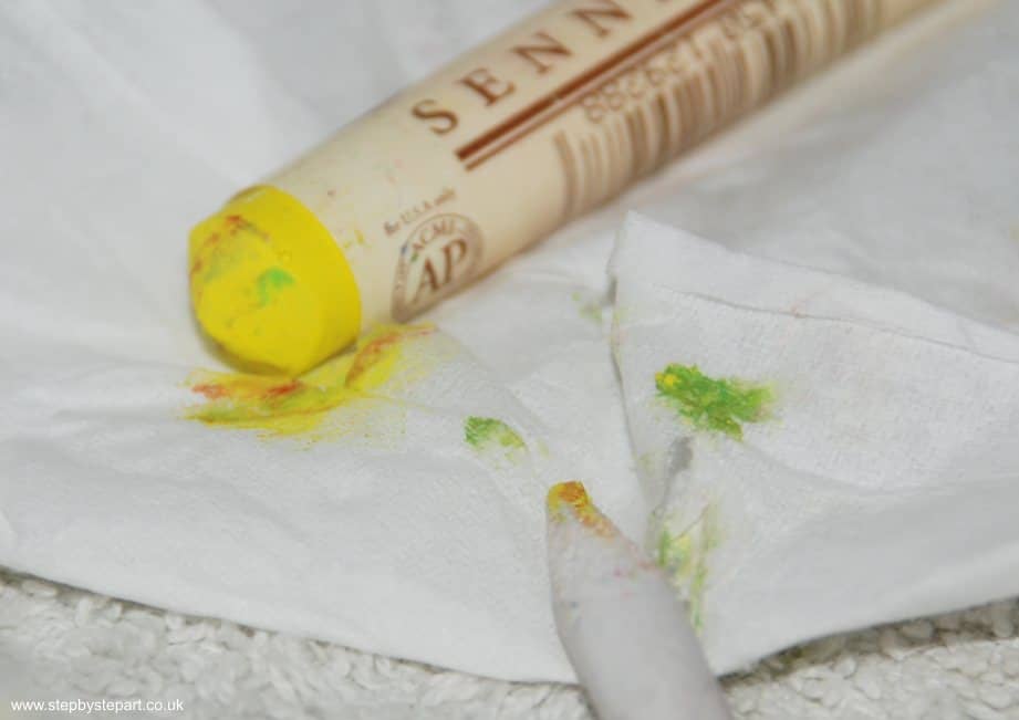 Cleaning the tip of an oil pastel and a paper stump in between oil pastel layers