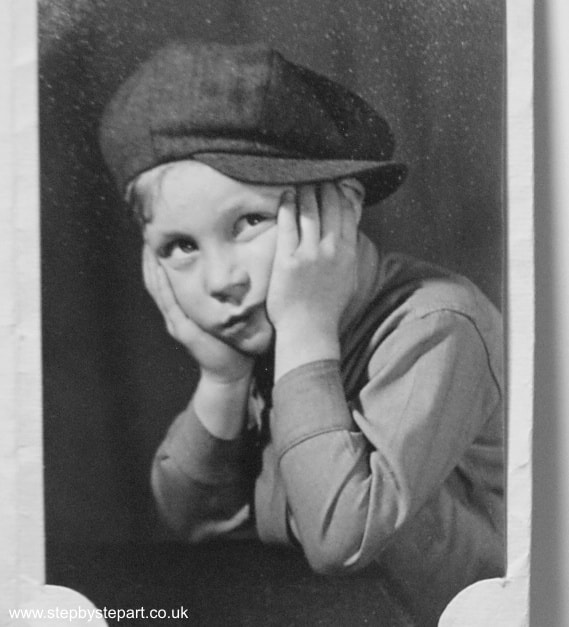 old 1940's photo of a little boy with a baker's hat on