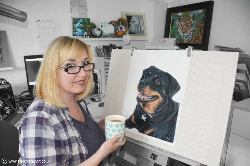 Artist Karen M Berisford working on a Coloured pencil portrait of a Rottweiler