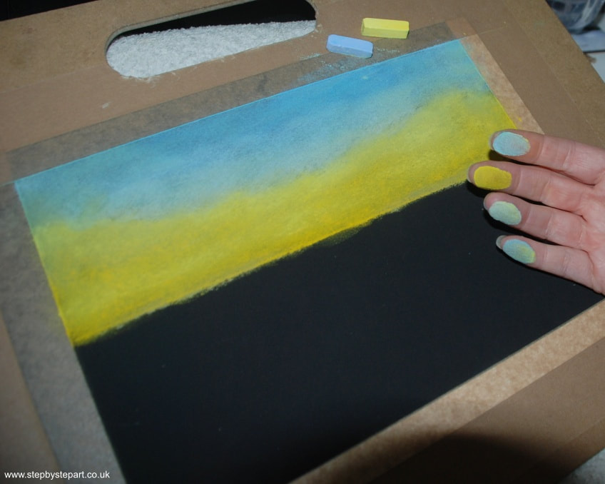 Finger blending a summer sky created in soft pastels