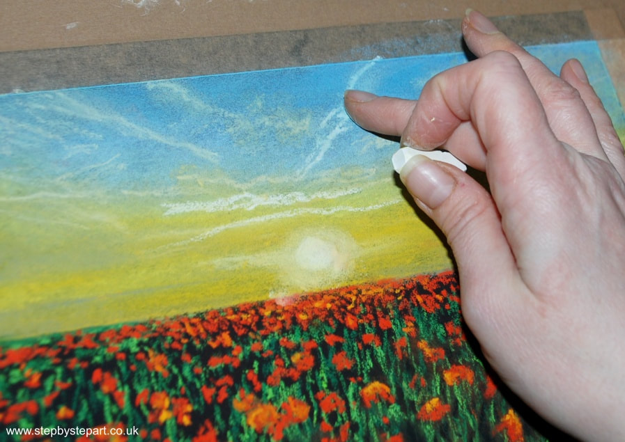 Applying a tangerine oil pastel on a drawing of a Strawberry