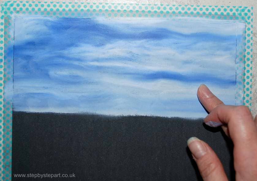 Blending oil pastels together to create a cloudy blue sky on dark sanded UArt paper