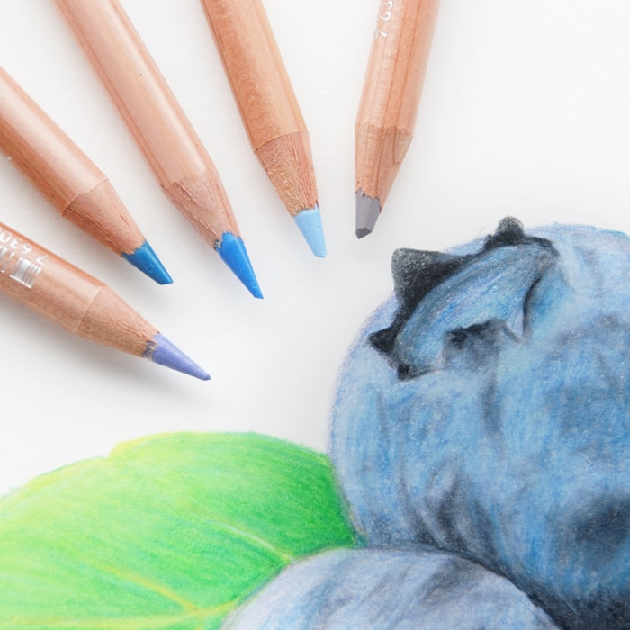 Caran d'Ache Luminance pencils and a blueberry drawn in coloured pencils