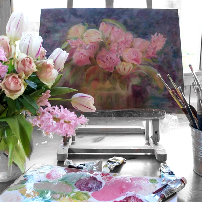 Tulips on the artists easel with paint and paintbrushes