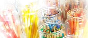 Coloured pencils in glass jars and colour charts
